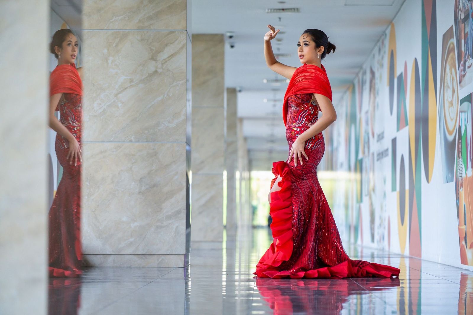 Frau in rotem Abendkleid in einem modernen, dunklen Korridor